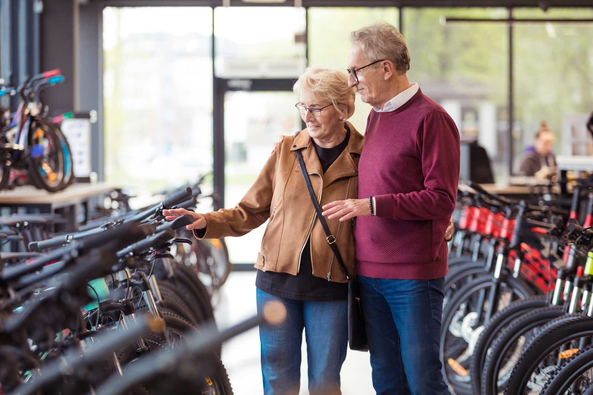 Senior woman and senior man looking at bicycles in bike shop