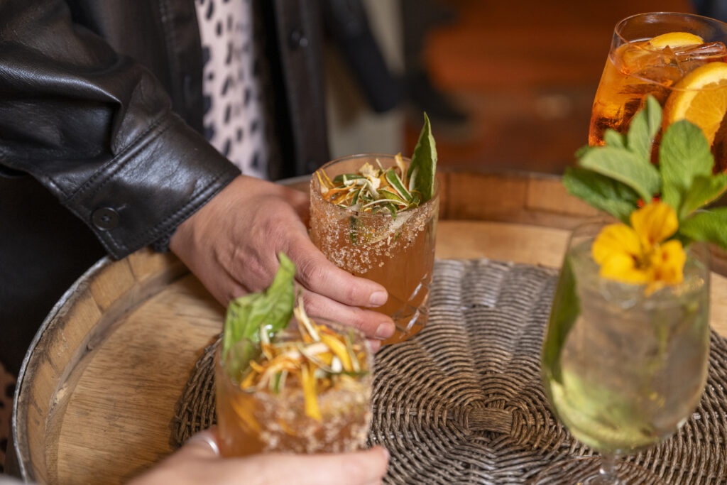 Cocktail drinks on a table with group of people enjoying a cocktail reception in a bar