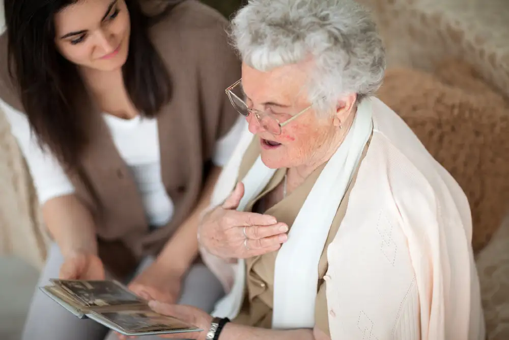a senior woman looking at old photos with her adult daughter