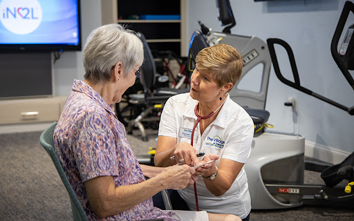 senior woman with her caregiver in a health club